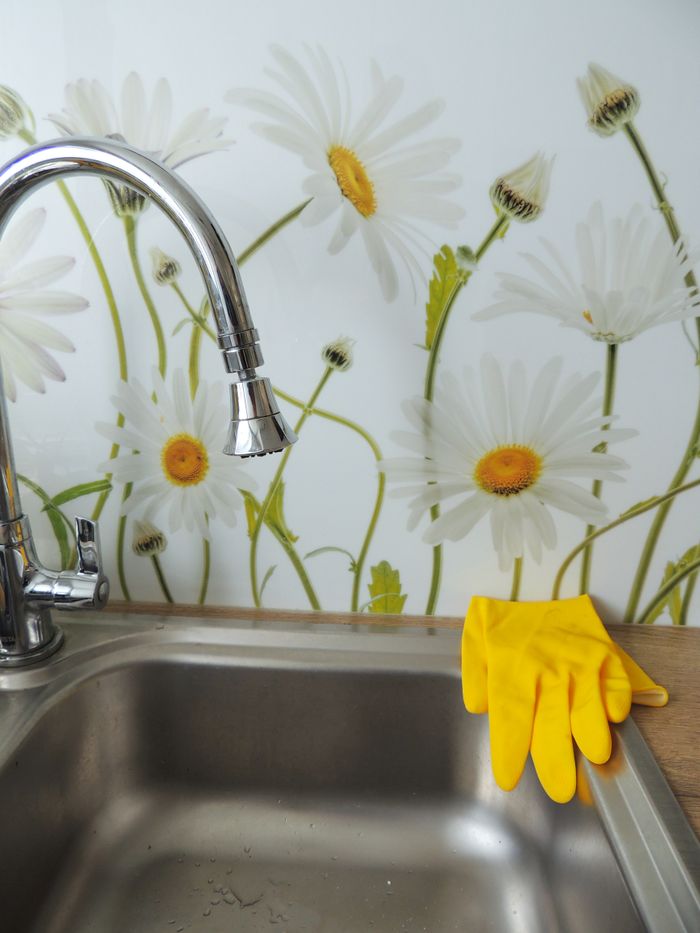 portfolio-04 Modern kitchen sink with daisy wallpaper and yellow cleaning gloves.